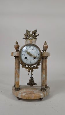 une horloge posée sur un socle en marbre
