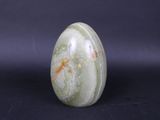a close up of a green marble on a black surface