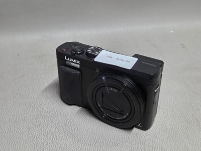 un petit appareil photo noir posé sur une surface blanche
