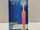 packaging of a pink electric toothbrush sitting on top of a white counter