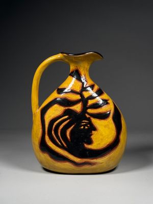an image of a yellow and black vase with a bird on it