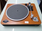 une platine avec un tourne-disque posé dessus, sur une table