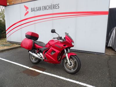 une moto rouge garée devant un immeuble