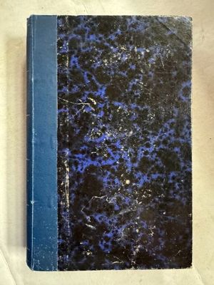 un livre bleu et noir posé sur une surface blanche