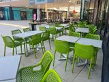 de nombreuses chaises et tables vertes à l'extérieur d'un restaurant
