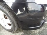 a black cat sitting on the front of a black car
