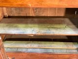 a wooden cabinet with a metal shelf on top of it