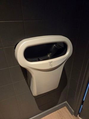a urinal in the corner of a bathroom stall