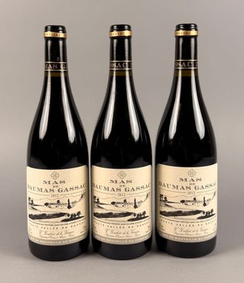 trois bouteilles de vin posées sur une table l'une à côté de l'autre