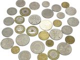 a close up of a pile of coins on a white surface