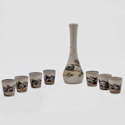 several shot glasses and a vase sitting on a white surface