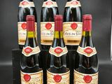 six bouteilles de vin sont alignées sur une table