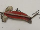 an old fishing lure on a white surface with a hook