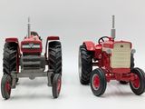 two toy tractors sitting next to each other on a white surface