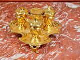 a gold candle holder on a red marble table