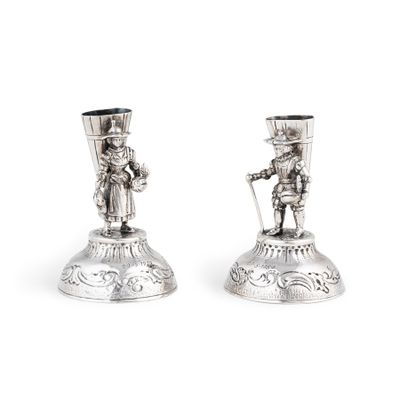 une paire de bougeoirs en argent ornés d'un homme et d'une femme