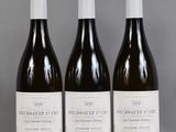 trois bouteilles de vin sont alignées sur une table
