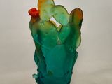 a glass vase with a cactus in it on a table