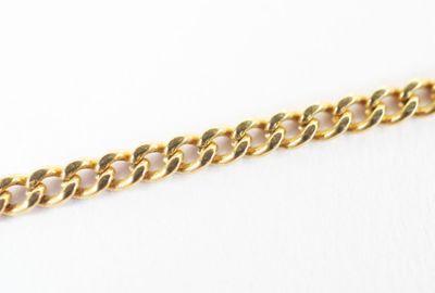 a close up of a gold chain on a white surface