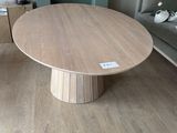 une table en bois avec un piètement en bois dans un salon