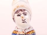 a small ceramic figurine of a man with a hat on