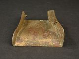an old brass plate with a handle on a black surface