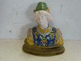 une figurine représentant un homme coiffé d'un chapeau vert, posée sur une table