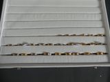 three pairs of gold and silver bracelets in a white box