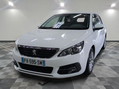 la voiture blanche est garée sur un sol en damier dans le garage