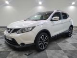 the white nissan suv is parked on a checkered tile floor