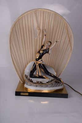 une statue représentant une femme tenant un éventail, posée sur une table