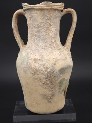 un vase très ancien posé sur un socle