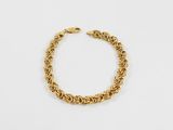 un bracelet à chaîne en or avec un fermoir sur fond blanc