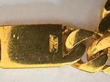 a gold plated bracelet with a chain attached to it