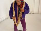 a figurine of a man wearing a hat and purple pants