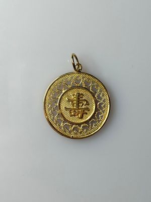 a gold coin with a crown on it sitting on a white surface