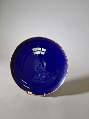 un gros plan d'une assiette bleue posée sur une surface blanche
