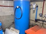 two blue barrels and a blue machine in a garage