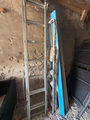 une échelle appuyée contre un mur, à côté d'un lit