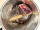 a small cigarette in a metal container on the floor