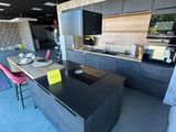 a kitchen with a black counter top and a pink chair