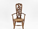 une vieille chaise en bois dont le dossier et l'assise sont sculptés