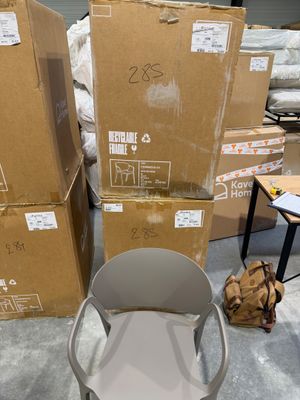 une pile de cartons et une chaise au milieu d'une pièce