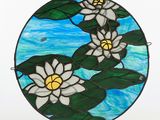 a picture of a stained glass sun catcher with white flowers on it
