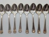 six spoons are lined up in a row on a white surface