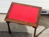a small table with a red top sitting on the sidewalk