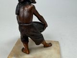 statue of a man kneeling on a marble base holding a bowl