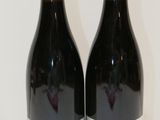 deux bouteilles de vin posées sur une table l'une à côté de l'autre