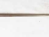 une petite épée posée sur une surface blanche