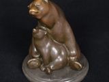 bronze statue of a bear and a cat on a black background